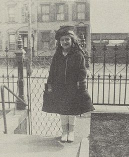 Ruth as a young girl standing outside.