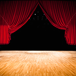 A red stage curtain pulled back.