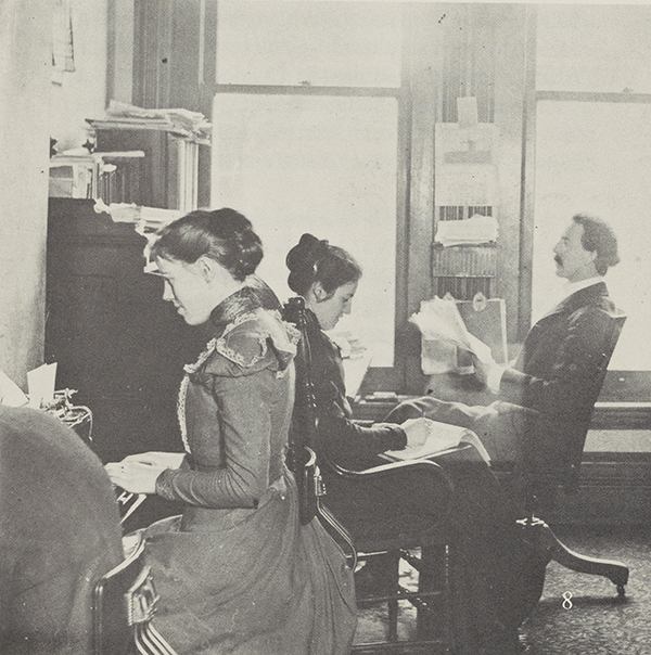 A view of Gregg Shorthand School, Chicago, two young women and a gentleman in the room.