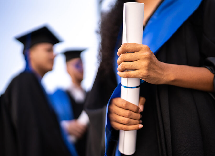 Close-up of a young woman holding a diploma on graduation