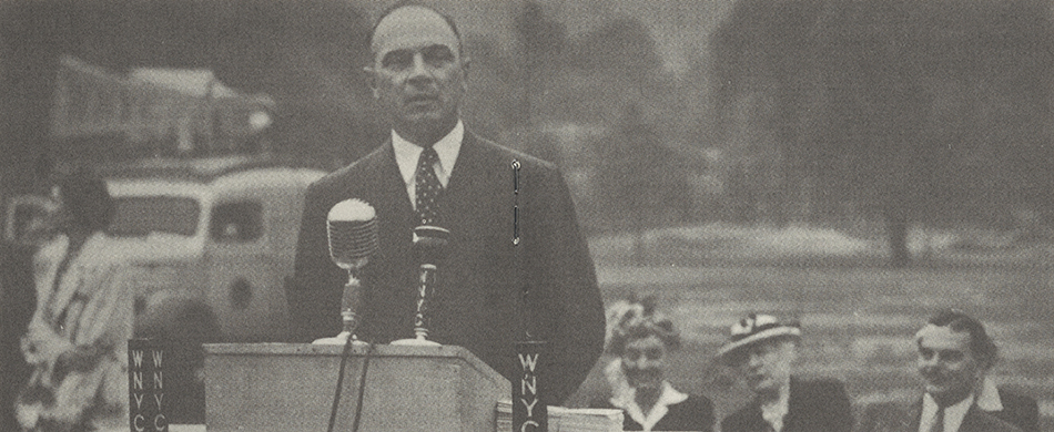 Gov. Thomas E. Dewey is among the guests at a July 1943 New York City Department of Parks Awards Ceremony. Ralph Hayes is at the microphone.