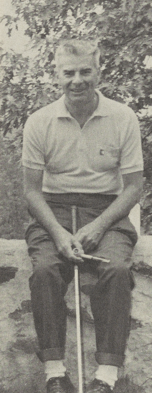 Lloyd sitting with his golf stick with tree leaves behind him in 1972.