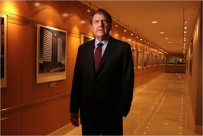 Richard LeFrak, the son of Samuel LeFrak, standing in a hallway lined with photos. Photo Credit: nytimes.com