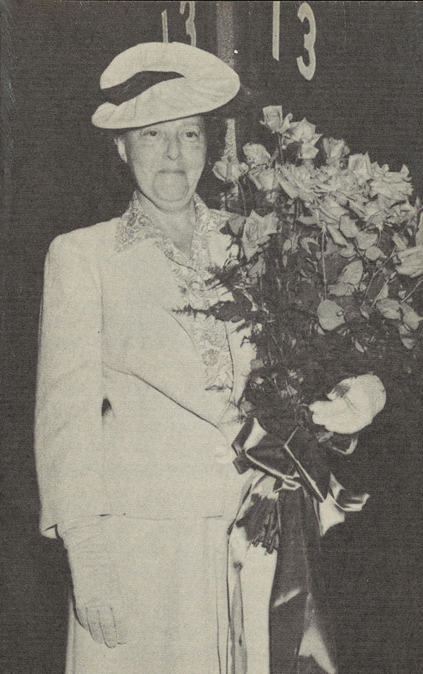 Reba Q. Lerch stands with a bouquet of flowers.