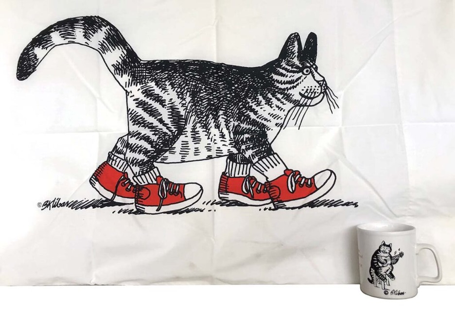 A black and white striped cat illustration walking with red shoes and white socks. A cup in the corner with a cat playing a stringed instrument. As president of Toni Mendez, Inc., she wore many hats, including licensor, merchandiser, syndicated feature representative, and literary agent.