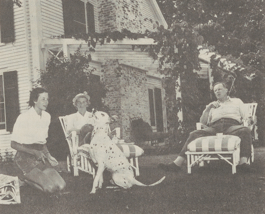 Serena and George Merck with daughter Judith in Vermont sitting outside a home with a dog. Photo Credit: Richard Pratt/TimeMagazine