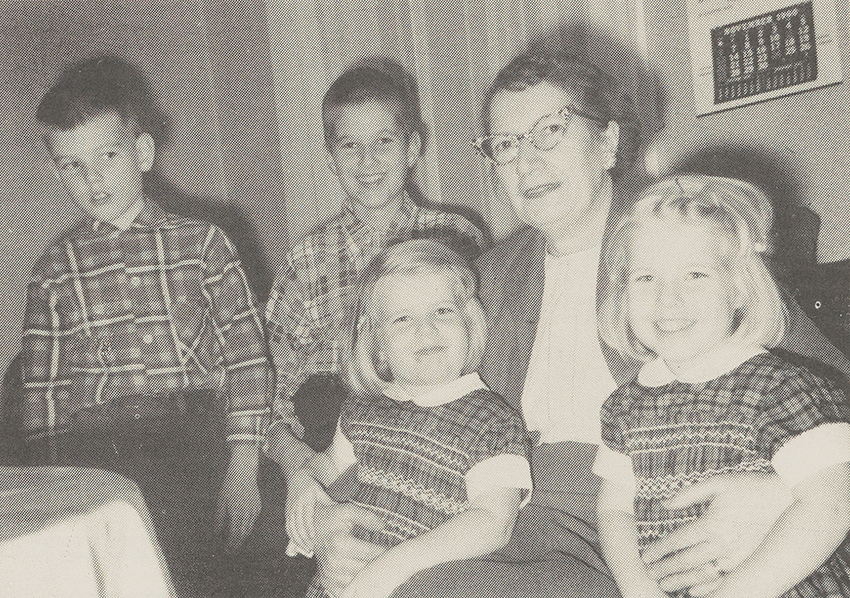 Sarah with her two grandnephews standing beside her and grandnieces in her arms in 1960.