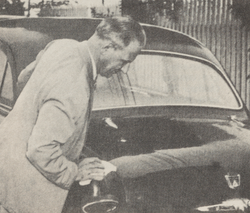With a cloth in his hand as he touches the back of a car, Harry Triantafillu demonstrates "Blue Coral."