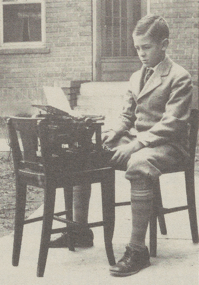 Herbert Buell West when he was a little older as a child in front of a typewriter.