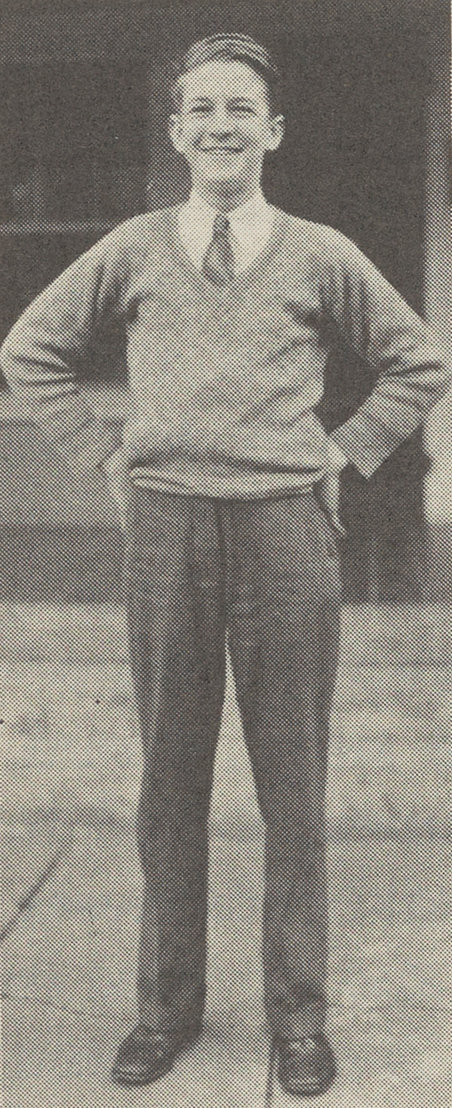 Herbert Buell West as a young man with his hands on his hips and a big smile.