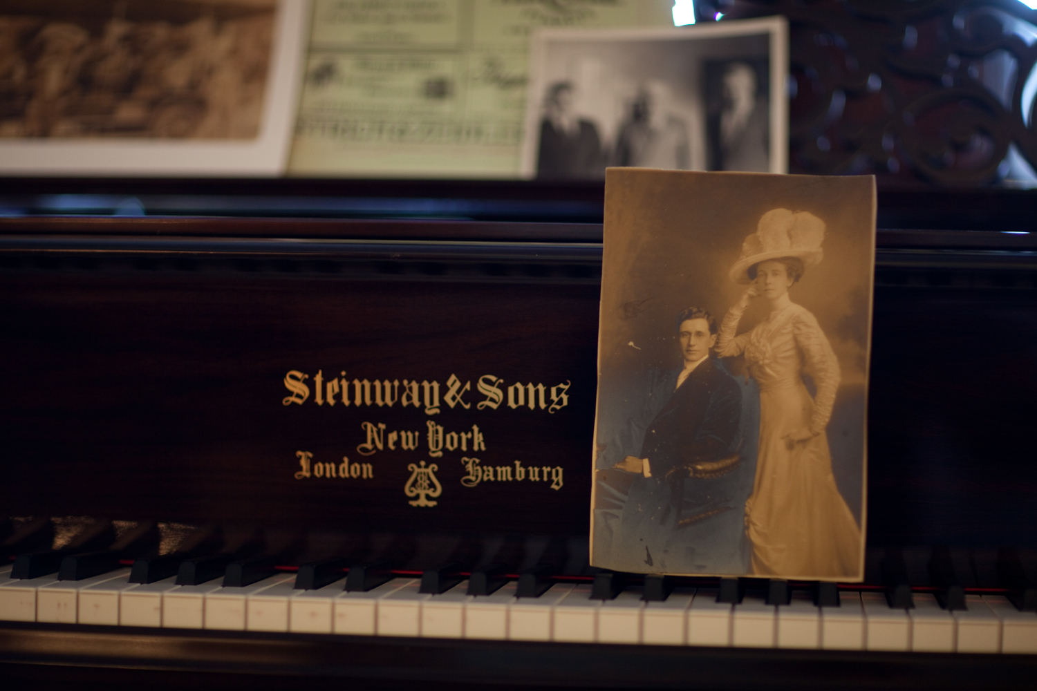 A black and white photo of a couple resting on the keys of a piano that says, "Steinway & Sons" New York, London, Hamburg. Photo source: msteinert.com.