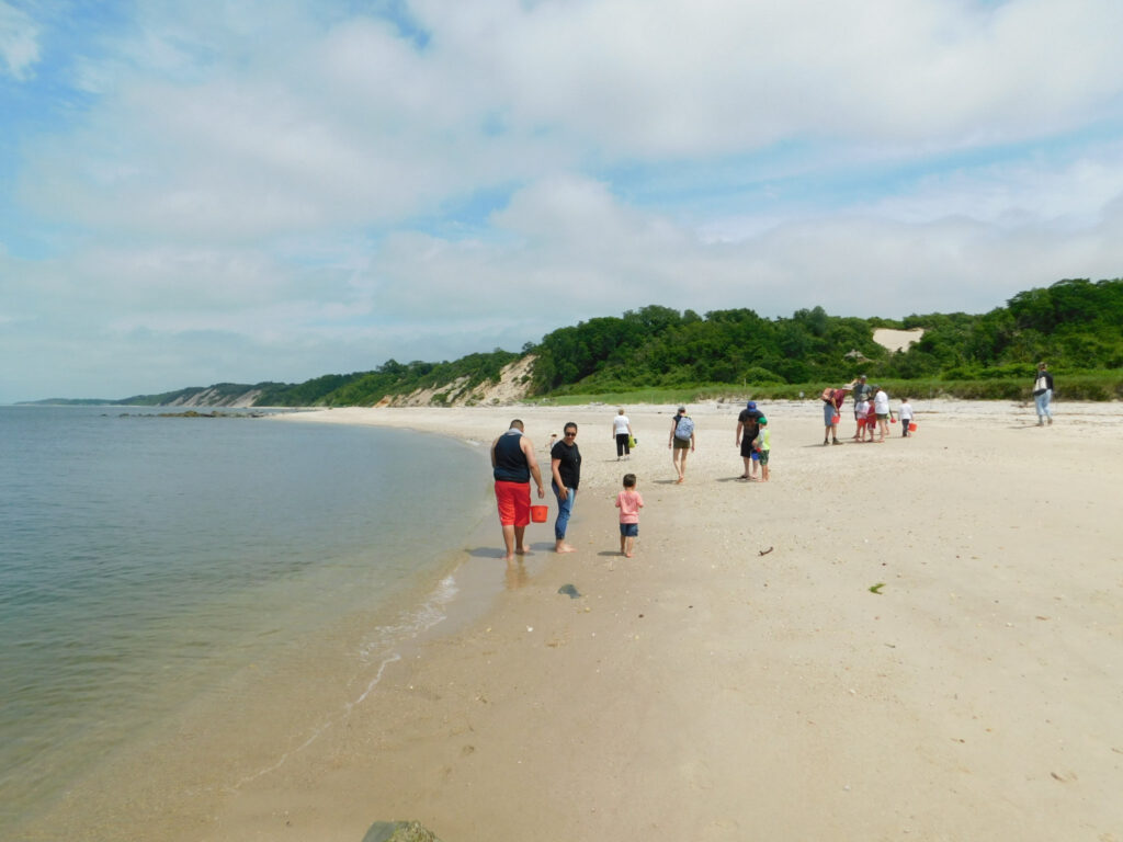 People walk along a beach in Long Island.