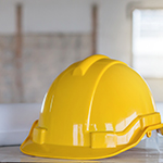A hard hat on a table with light coming in from a window.