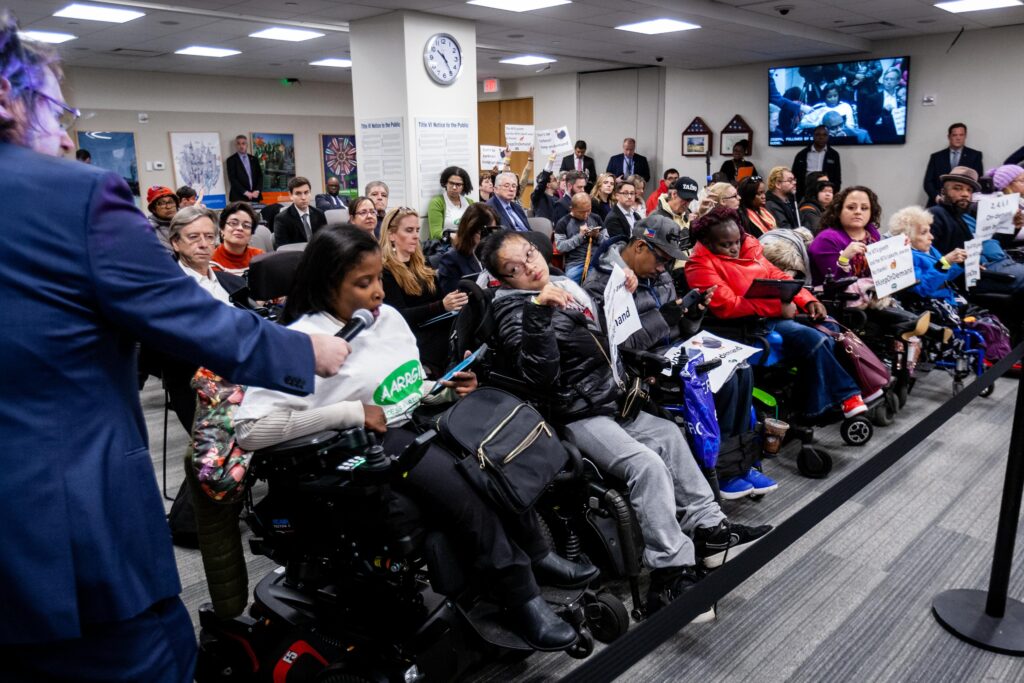 Wheelchair users of Access-A-Ride Reform Group hold signs and advocate for accessible public transportation.