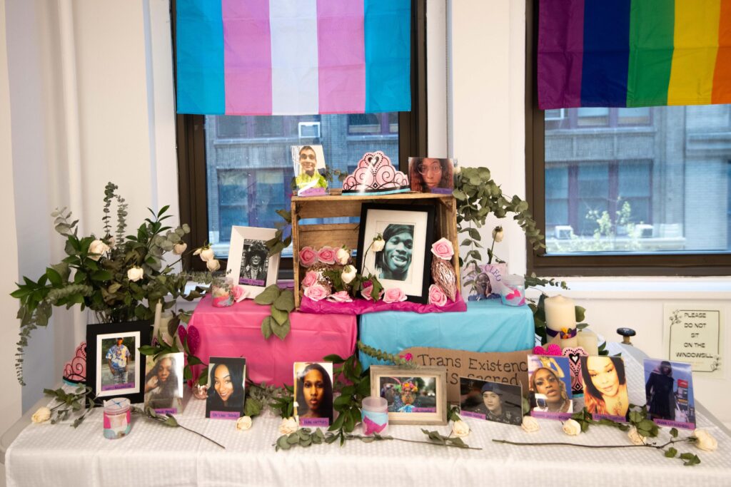 A commemoration of photos, candles, and flowers to honor Ali Forney and trans existence.