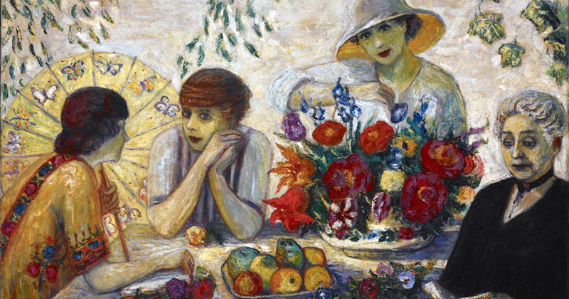 A vintage painting of four women sitting around a table with flowers and fruits placed on it.