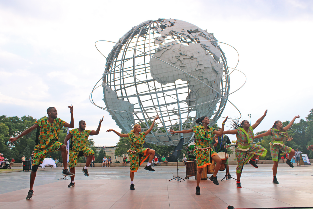 Dancers performing in front of the Unisphere in Flushing Meadows Corona Park.
