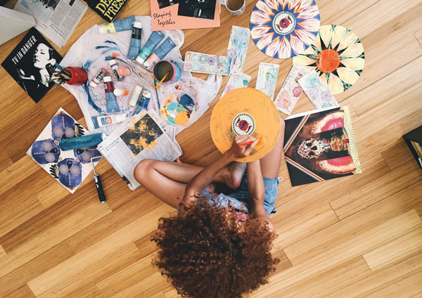 A young artist photographed from above while painting vinyl records. 