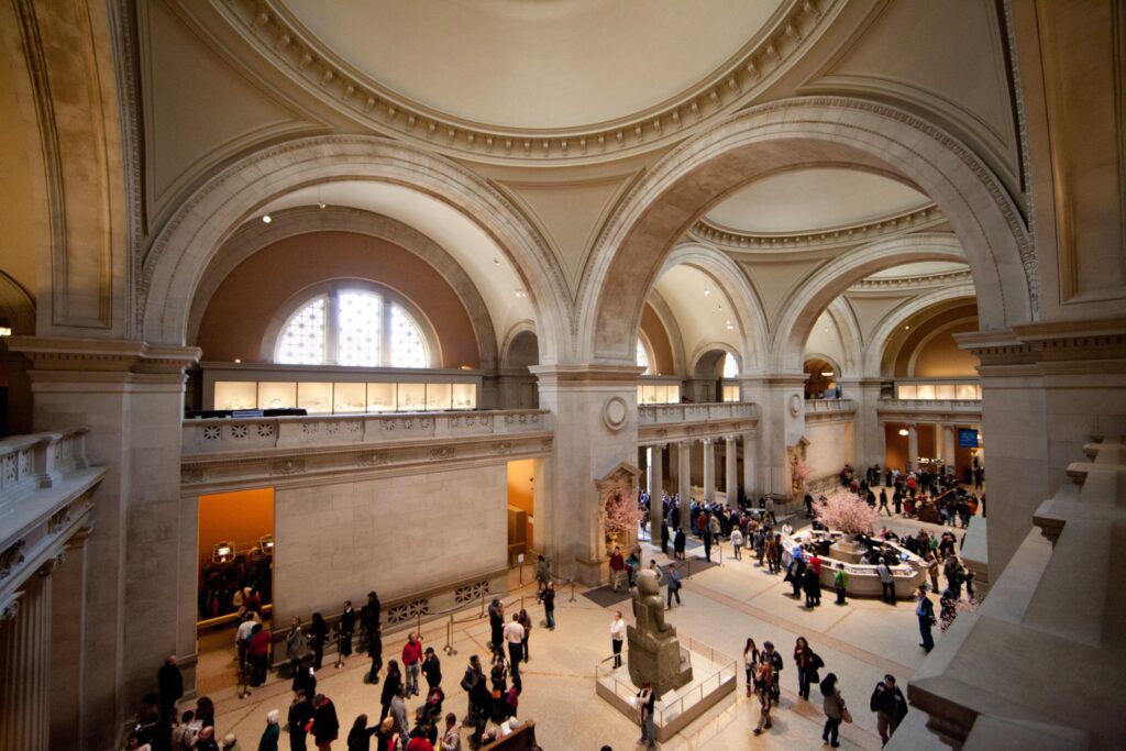 People walking around inside the Metropolitan Museum of Art.