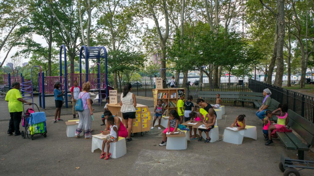 Children participating in reading and drawing programs in the park.