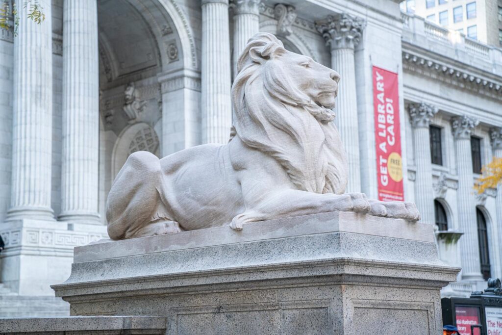 A large marble lion sculpture in front of the New York Public Library.