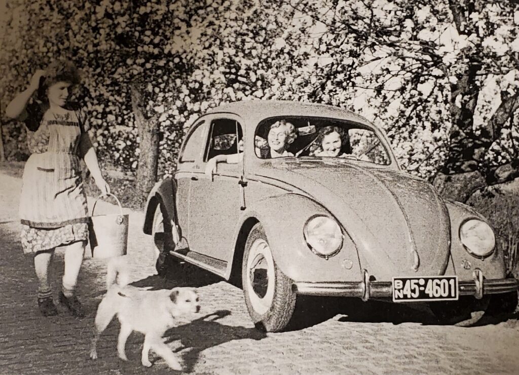 Two women inside a VW Beetle.