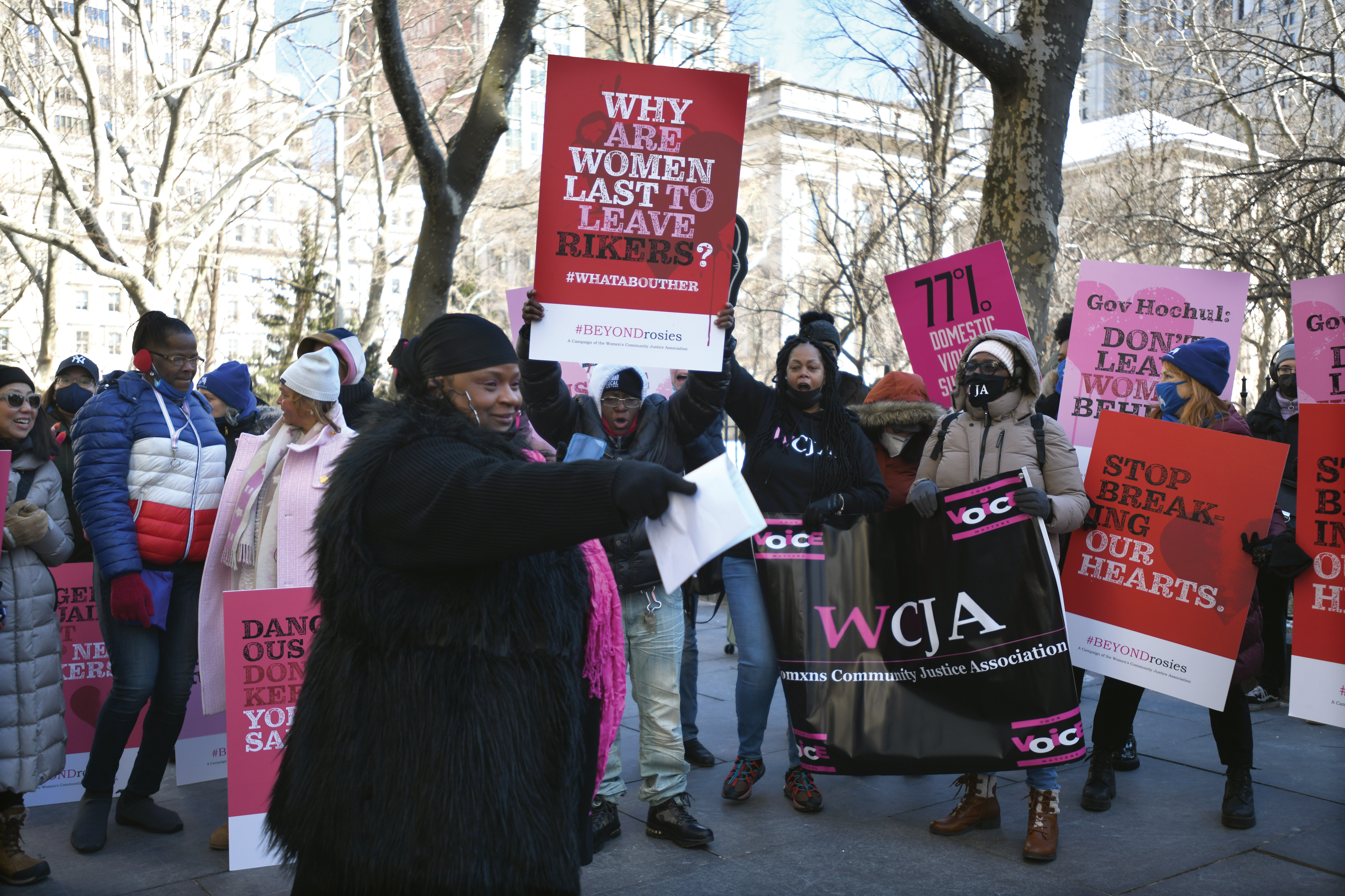 Adults attend a rally with large signs