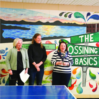 The Trust's Westchester leadership and Ossining Mayor stand in front of a mural that reads: The Ossining Basics.