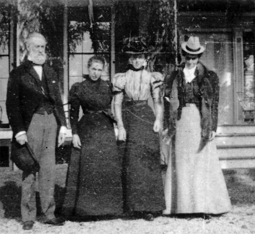 Standing outside a building, James with wife Henrietta and daughters Grace and Edith.