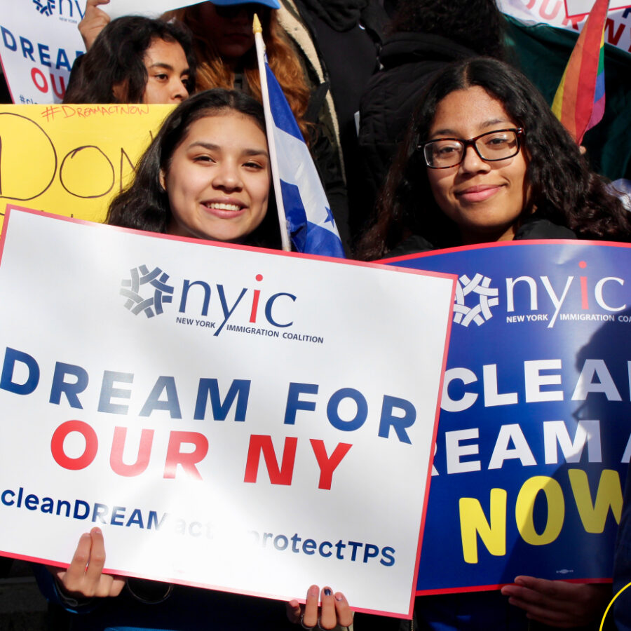 Two women holding signs at a rally.