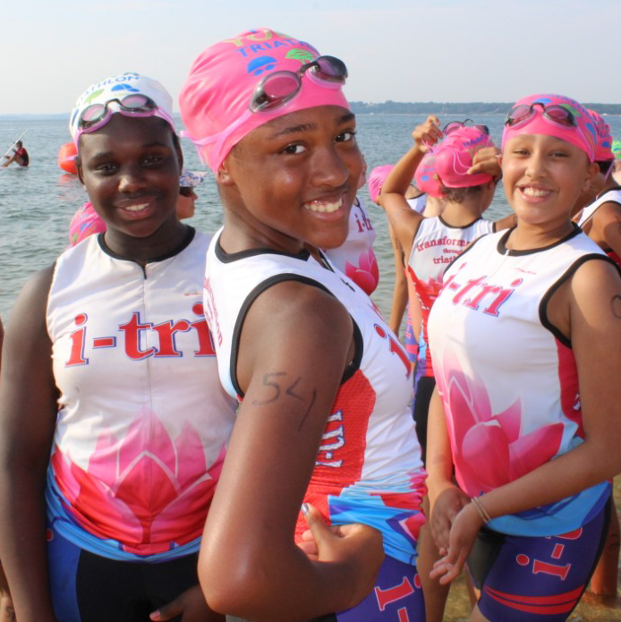 Girls in swimsuits get ready for triathlon practice.